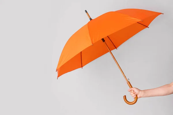 Mão feminina com guarda-chuva no fundo claro — Fotografia de Stock