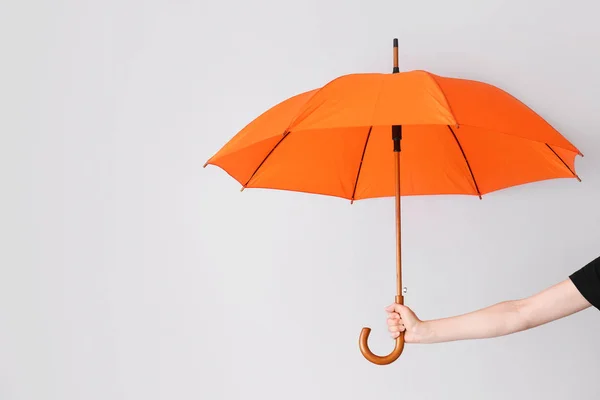 Main féminine avec parapluie sur fond clair — Photo
