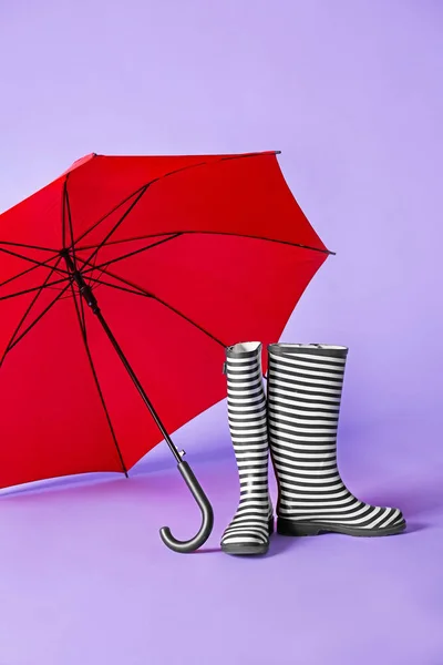 Gumboots e guarda-chuva em fundo de cor — Fotografia de Stock