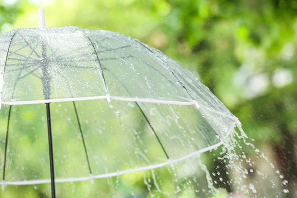 Transparent umbrella outdoors on rainy day — Stock Photo, Image