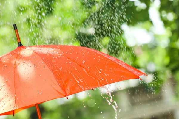 Bright umbrella outdoors on rainy day — Stock Photo, Image