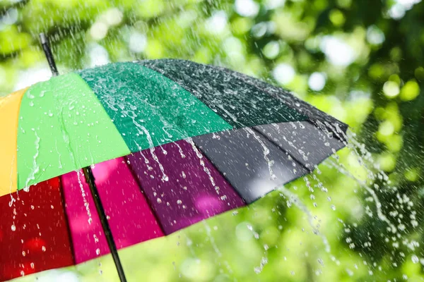 Цветной зонтик на открытом воздухе в дождливый день — стоковое фото