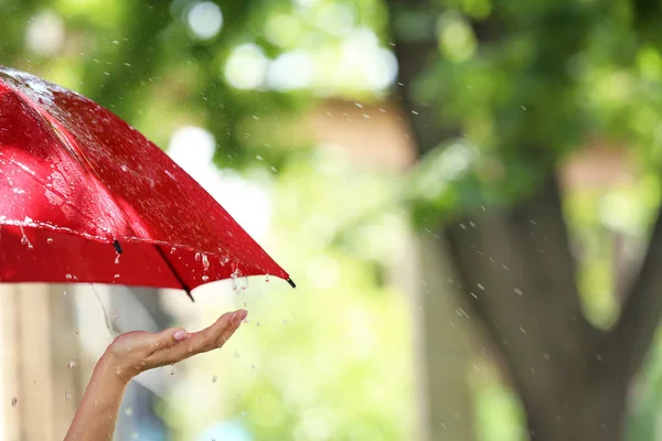 Frau mit rotem Regenschirm an Regentagen im Freien — Stockfoto