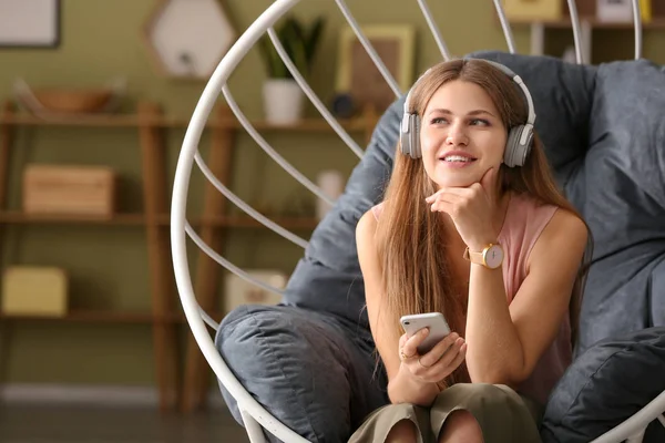 Mladá žena naslouchající audiobooku doma — Stock fotografie