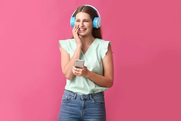 Jonge vrouw luisteren naar Audioboek op kleur achtergrond — Stockfoto