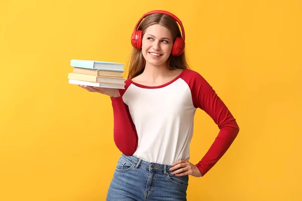 Νεαρή γυναίκα ακούγοντας ηχητικό βιβλίο στο χρώμα φόντου — Φωτογραφία Αρχείου