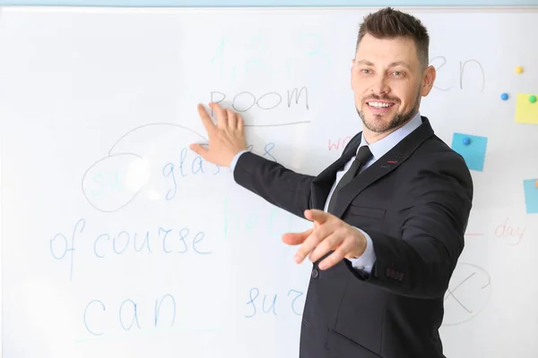 Beau professeur masculin près du tableau noir en classe — Photo