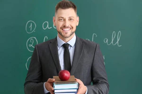 Beau professeur masculin près du tableau noir en classe — Photo