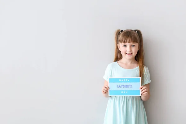 Linda niña con tarjeta de felicitación para el Día del Padre sobre fondo claro — Foto de Stock
