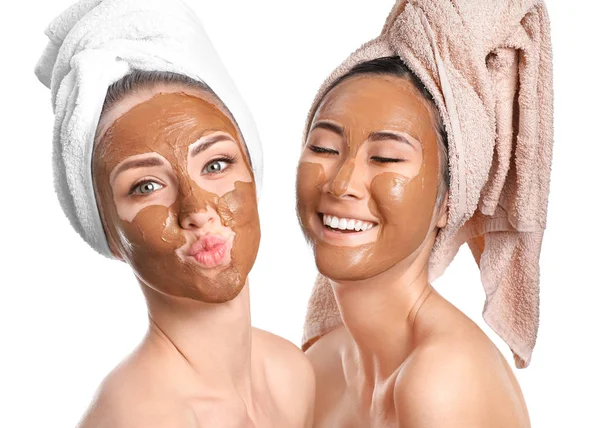 Hermosas mujeres con máscaras faciales sobre fondo blanco — Foto de Stock