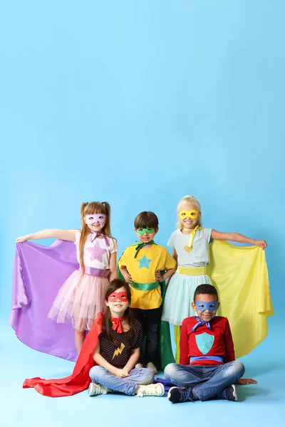 Cute little children dressed as superheroes on color background — Stock Photo, Image