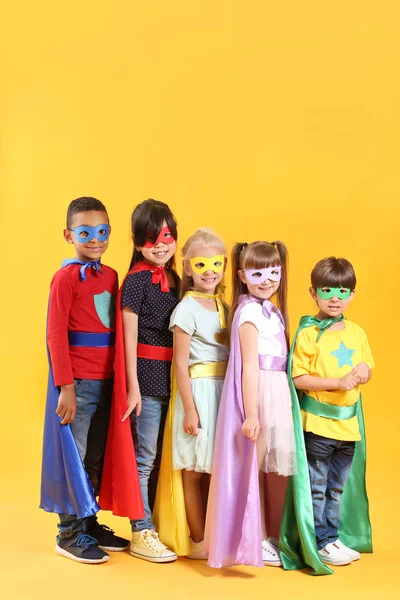 Cute little children dressed as superheroes on color background — Stock Photo, Image