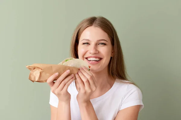 Mujer comiendo taco sabroso sobre fondo de color — Foto de Stock