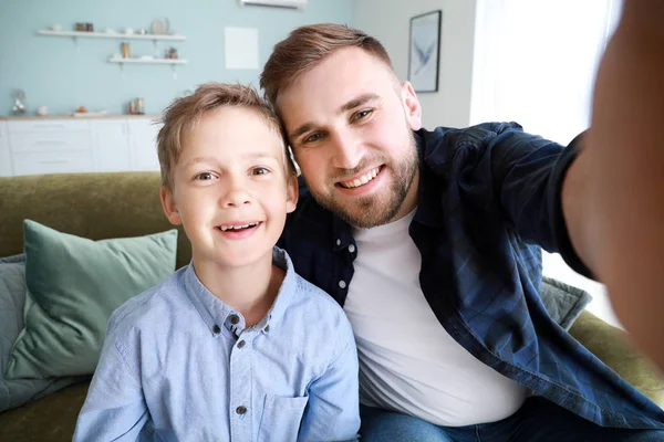 Portrait of happy father and son taking selfie at home — Stock Photo, Image