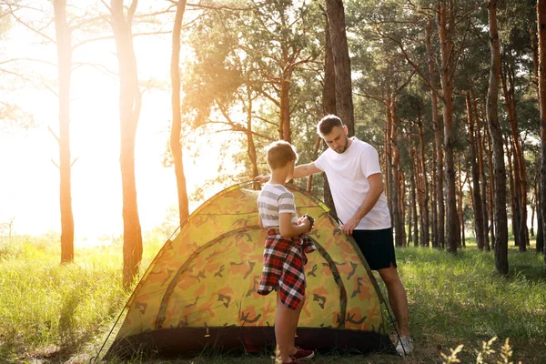 Apa és az ő kisfiát elhelyezés fel kemping sátor erdőben — Stock Fotó