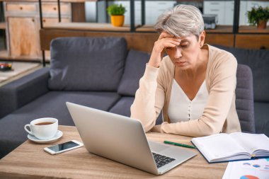 Ofiste çalışan yorgun olgun iş kadını