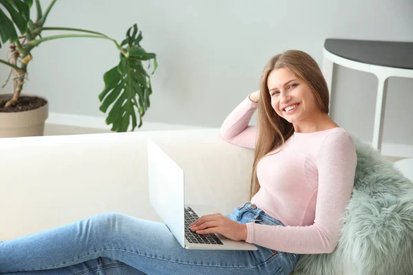 Mooie jonge vrouw met laptop thuis — Stockfoto