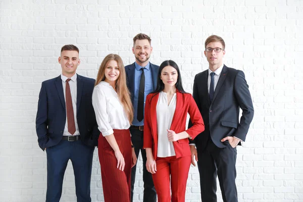 Team of business people near white brick wall — Stock Photo, Image