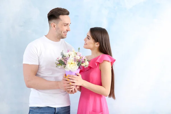 年轻夫妇与美丽的花花束在轻的背景 — 图库照片