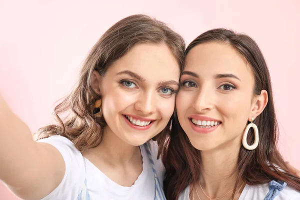 Retrato de pareja lesbiana feliz tomando selfie sobre fondo de color — Foto de Stock