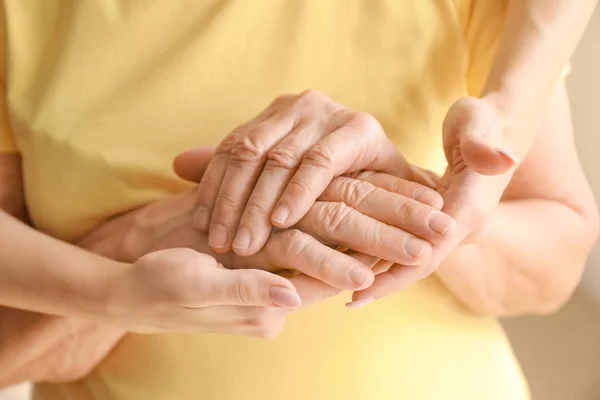 Mani di donna anziana e sua nipote, primo piano. Concetto di cura e sostegno — Foto Stock