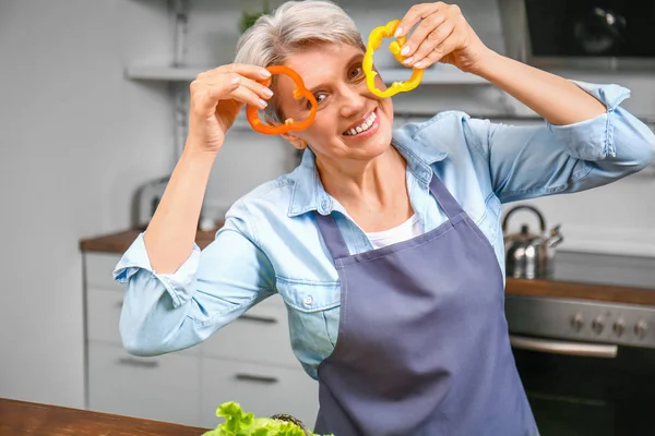 Mutfakta biber parçaları ile Olgun kadın — Stok fotoğraf