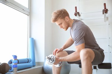 Spor salonunda Dambıl ile sportif genç adam eğitim