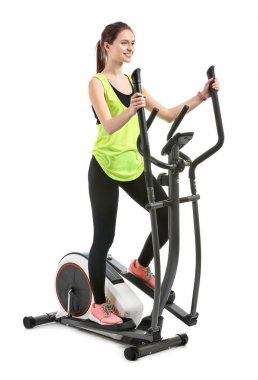 Beyaz arka plana karşı makinede sportif genç kadın eğitimi