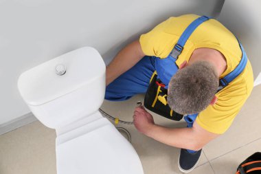 Tesisatçı tuvalette çalışıyor