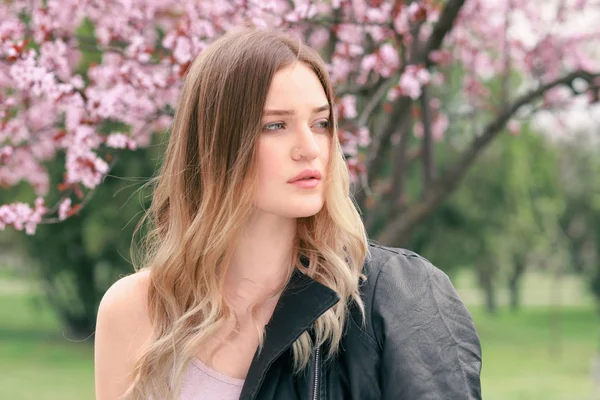 Portret van mooie jonge vrouw in Park op de voorjaars dag — Stockfoto