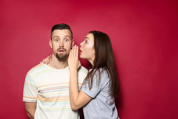 Gossiping giovane coppia su sfondo di colore — Foto Stock