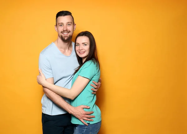 Счастливая молодая пара на цветном фоне — стоковое фото