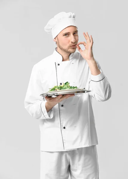 Bonito chef masculino com salada no fundo branco — Fotografia de Stock