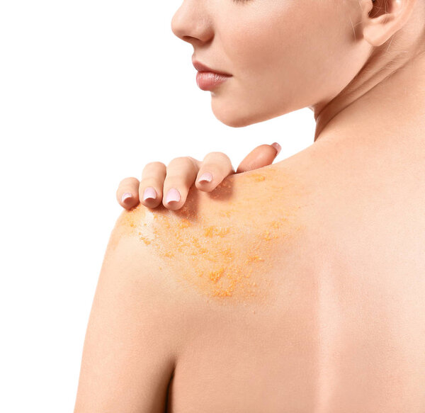 Молодая женщина с оранжевым телом скраб на ее теле на белом фоне, крупным планом
