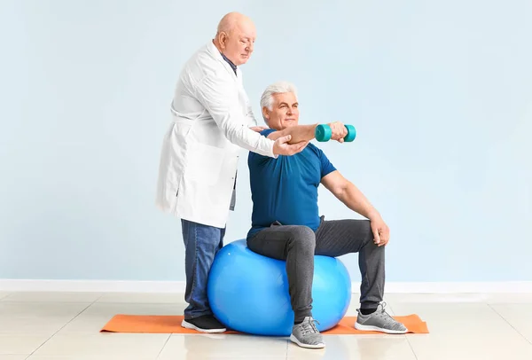Senior physiotherapist working with mature man in clinic — Stock Photo, Image