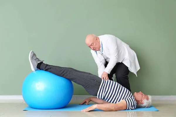 Senior physiotherapist working with mature man in clinic — Stock Photo, Image