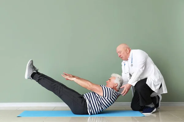 Senior physiotherapist working with mature man in clinic — Stock Photo, Image