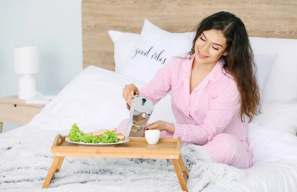 Beautiful young woman having breakfast in bed — Stock Photo, Image
