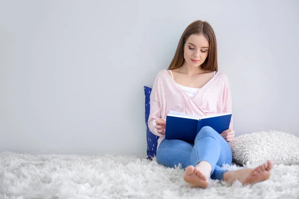 Bella giovane donna che legge libro a casa — Foto Stock