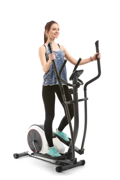 Sporty young woman training on machine against white background — Stock Photo, Image