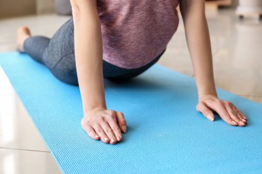 Evde yoga yapan genç bir kadın.