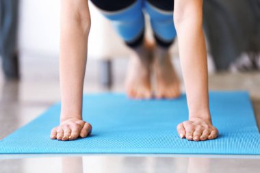 Evde yoga yapan genç bir kadın.