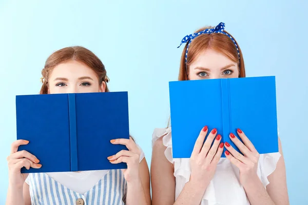 Portrait of beautiful young women with books on color background — Stock Photo, Image