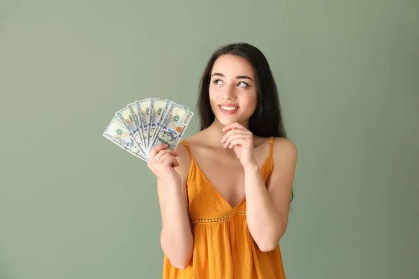 Mujer joven feliz con billetes de dólar en el fondo de color — Foto de Stock