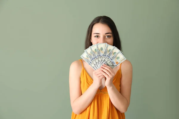 Mujer joven feliz con billetes de dólar en el fondo de color —  Fotos de Stock