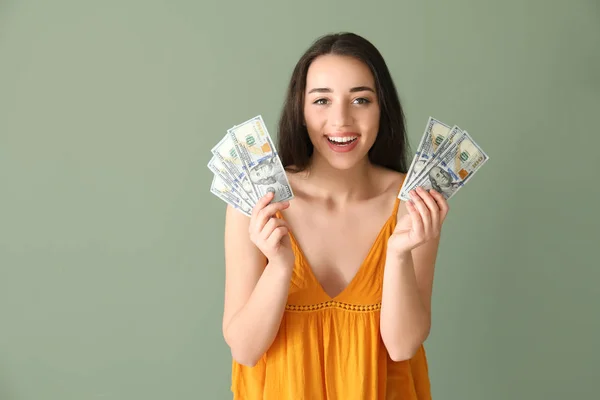 Boldog, fiatal nő, dollár-bankjegyek színes háttérrel — Stock Fotó