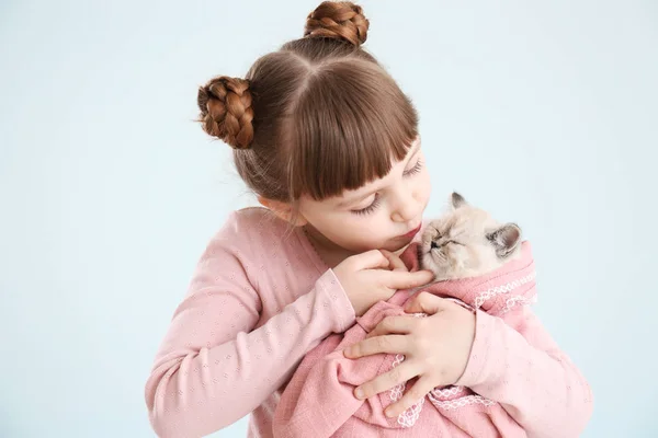 Dívka s roztomilým koťátem na světlém pozadí — Stock fotografie