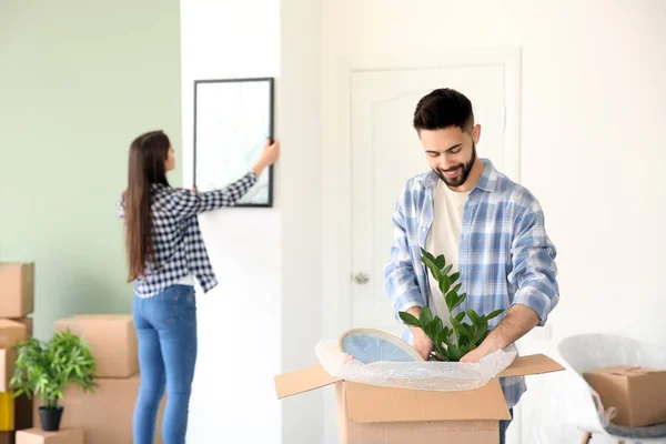 Casal jovem desempacotando pertences em sua nova casa — Fotografia de Stock