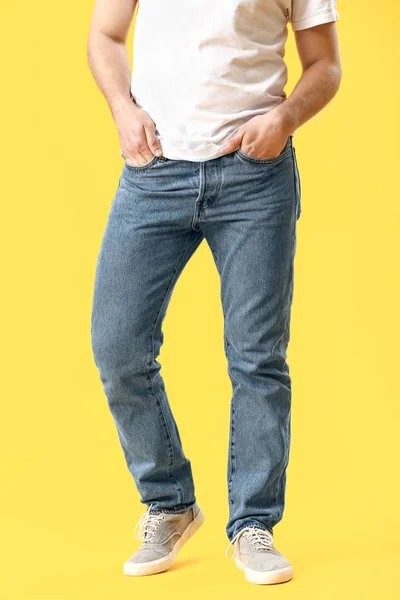 Stylish young man in jeans on color background — Stock Photo, Image