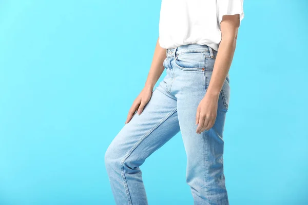 Mujer joven con estilo en jeans sobre fondo de color —  Fotos de Stock
